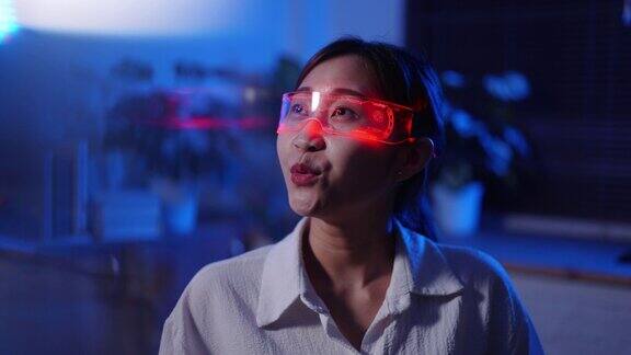 一名年轻的亚洲女子戴着虚拟现实耳机玩网络游戏背景是霓虹灯