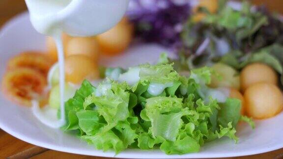 把调味汁倒在蔬菜沙拉上