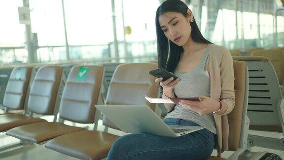 商务人士在机场使用手机和笔记本电脑