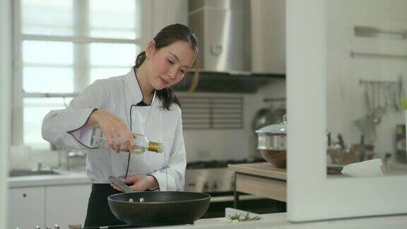 美丽的亚洲女厨师在厨房做饭