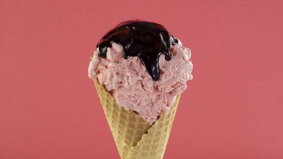 旋转草莓冰淇淋在蛋筒与巧克力酱