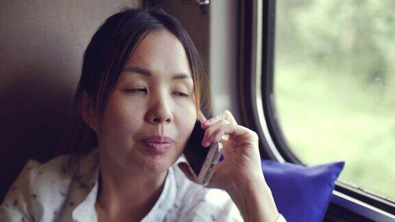 亚洲女性乘火车旅行时使用手机