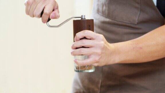专业咖啡师用手工研磨机在手工过程中研磨咖啡