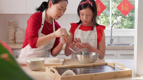 母亲在教女孩怎么包饺子