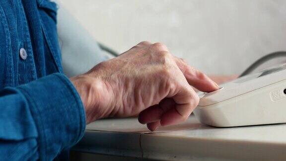 一个退休老人在家测量自己血压的特写老年人在测量压力时按下眼压计显示按钮有选择性的重点