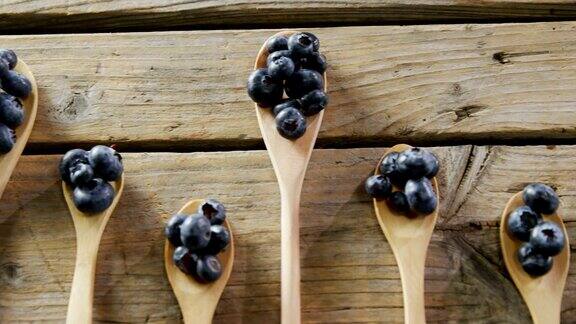 几勺蓝莓放在4k木桌上