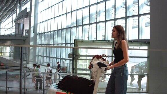 飞机上的乘客步行把行李拖到登机口在旅客大厅