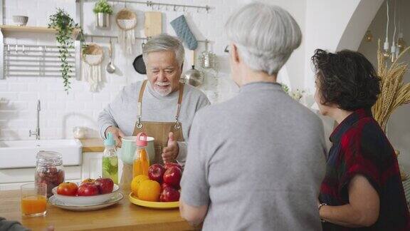 一群亚洲老年人朋友在厨房为朋友制作果汁五颜六色的水果和蔬菜健康饮食
