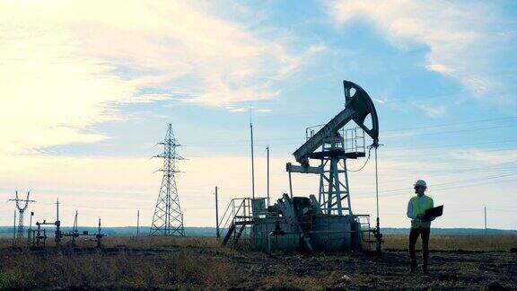 一个人带着井架走在田野上石油开采行业概念