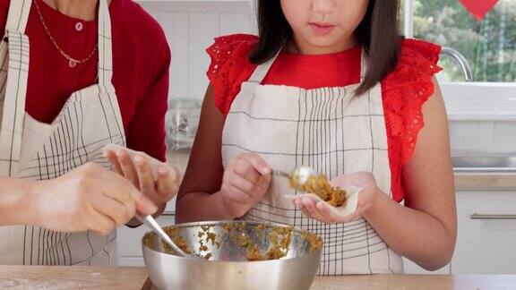母亲在家里教孩子在厨房里为中国节日做饭在中国妈妈和女儿一起为聚会或活动做传统的晚餐