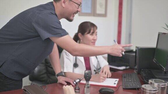 亚洲华人中年男性医生与他的医生同事讨论