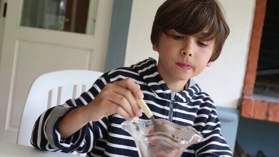 小男孩用勺子吃冰淇淋甜点