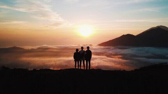 一群朋友站在巴图尔山顶在巴厘岛看在4K日出