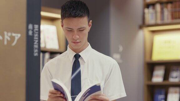 年轻的男学生正在阅读一本商业教科书
