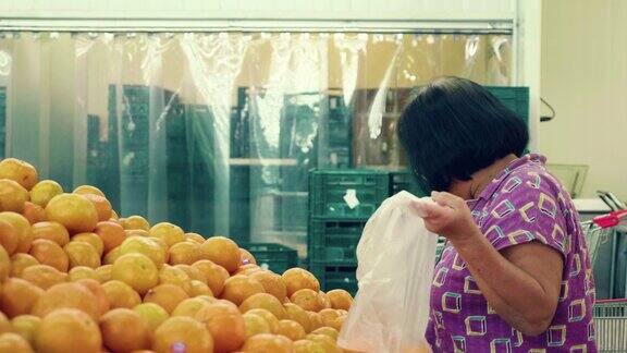 资深亚洲妇女购买水果和蔬菜摊