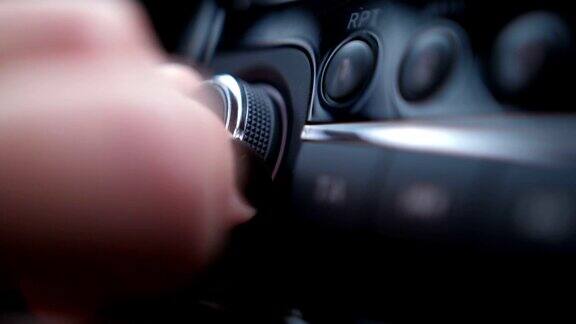 特写镜头女性手指按下启动按钮调整车内音量滚轮4K慢动作
