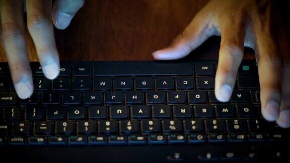 特写一个印度男人的手在电脑键盘上打字