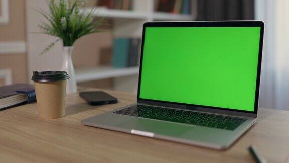 笔记本电脑与绿色模拟屏幕在桌面舒适的家庭办公室