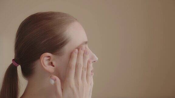 年轻女子用洁面泡沫洗脸进行护肤程序