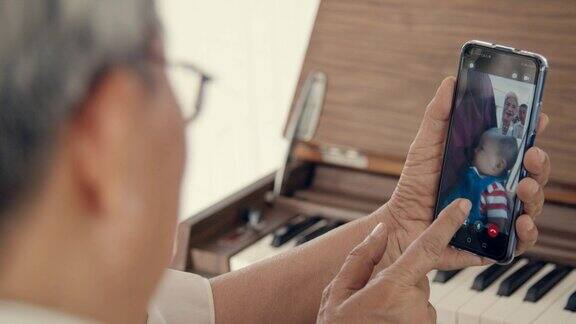 爷爷奶奶在家里用智能手机和孙子聊天