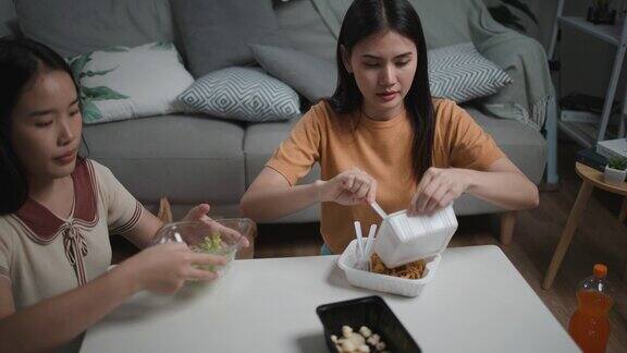 聚会后年轻女子和朋友在家里帮忙清理食物和饮料