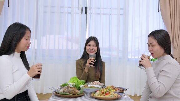 一群年轻的亚洲女性朋友坐在一起吃传统的亚洲食物如泰国当地食物