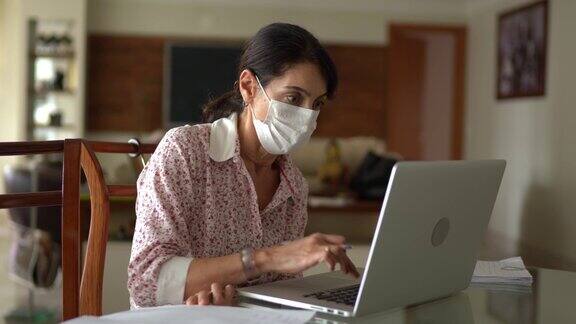 高级商务女性在家工作戴着防护面具