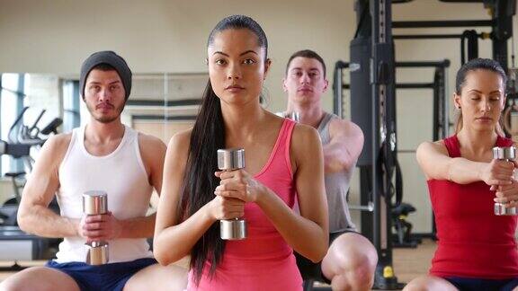 健身班在健身房用哑铃锻炼