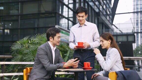三位亚洲商务人士在户外咖啡馆会面