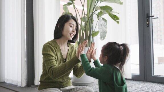 一位年轻的中国母亲和她的女儿在玩游戏