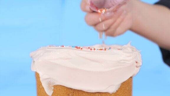 糕点师用彩球装饰奶油蛋糕美丽的手工制作的甜点