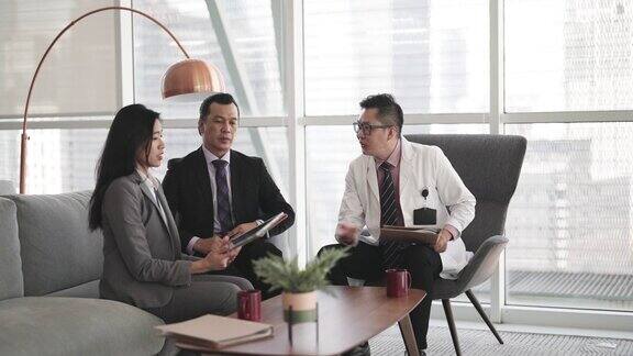 亚洲医院管理者在医生办公室业务会议上向医生介绍医药销售代表
