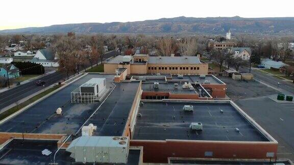 大型学校建筑的无人机镜头设置在一个小镇的中心背景是美丽的山脉