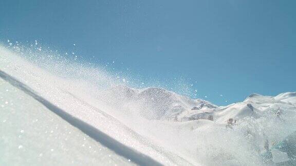近景:滑雪者拖着她的手沿着粉末雪道而骑下