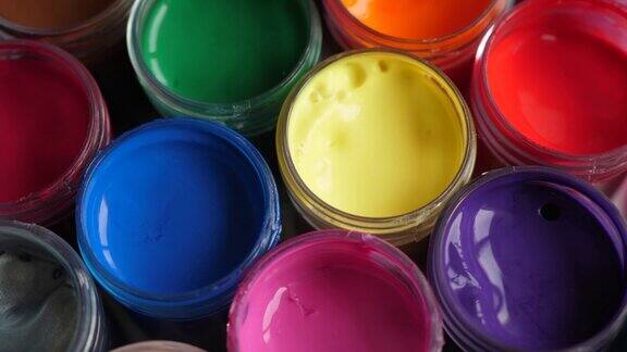 设置水粉颜料在罐子明亮的颜色接近旋转套多色水粉上的塑料罐旋转多色背景多色涂料的背景创意绘画艺术爱好