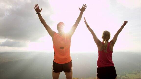 TSSLOMO跑步夫妇在日落时到达山顶
