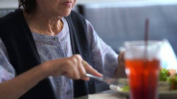 亚洲资深女性吃牛排退休概念