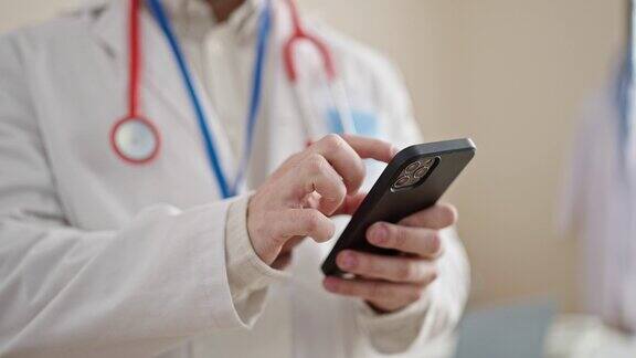 年轻的西班牙裔医生在诊所使用智能手机