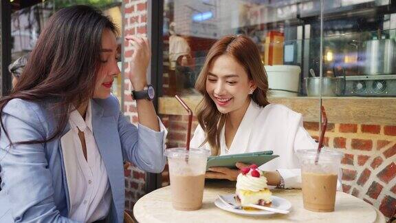 两个亚洲女商人在户外咖啡店一起工作