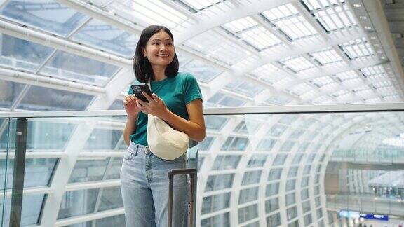 玩手机通讯在候机楼内等候登机的女子旅行