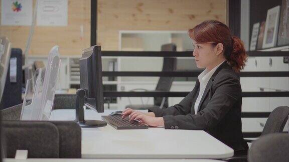 女商人在办公室的办公桌上使用台式电脑多莉拍摄