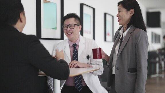 茶歇期间亚裔华人医生在医院咖啡厅与医院管理人员讨论