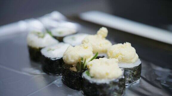 寿司日本的食物烹饪烹饪寿司师傅正在用奶油芝士、黄瓜、米饭、海苔制作寿司卷特写镜头在餐厅的厨房
