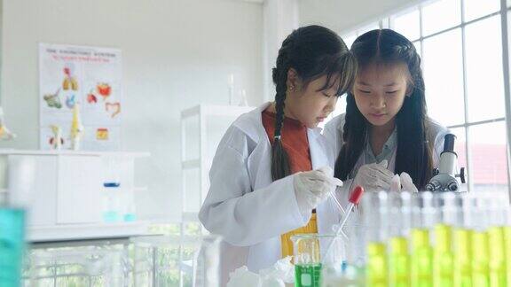 小学生STEM学校的学生在科学课上用显微镜检查和观察一些东西