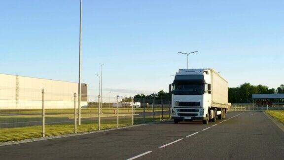 在高速公路上行驶的带有货物拖车的半卡车白色卡车通过工业仓库区域运送货物