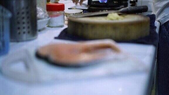 妇女烹饪和鲑鱼在厨房机架焦点