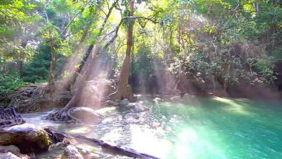 瀑布和美丽的热带自然与阳光透过树泰国北碧府四面瀑布4K分辨率