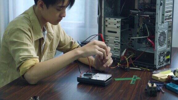 亚洲学生在教室里使用测量仪器修理电子电脑硬件