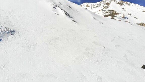 冬季高山登山队在高海拔山峰上排成一行行走的镜头
