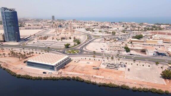 拉斯alKhaimah海滨大道和酋长国的市中心地区的空中城市景观地标性的摩天轮和一座清真寺